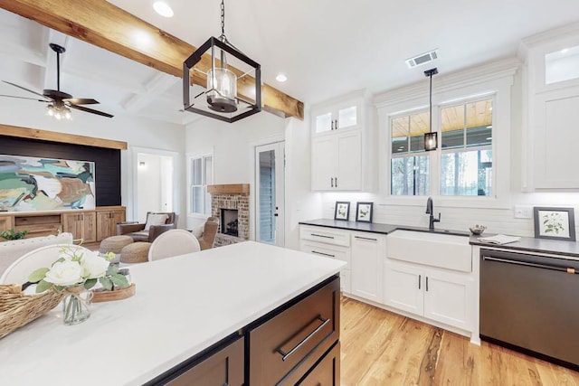 kitchen featuring a sink, visible vents, open floor plan, light wood-type flooring, and dishwasher