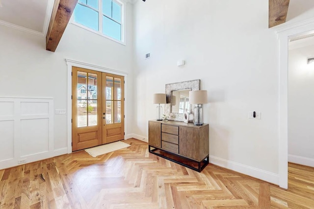 foyer featuring plenty of natural light, baseboards, and french doors