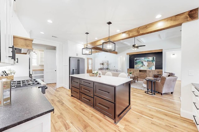 kitchen featuring light wood-style flooring, open floor plan, beamed ceiling, white cabinetry, and high end fridge