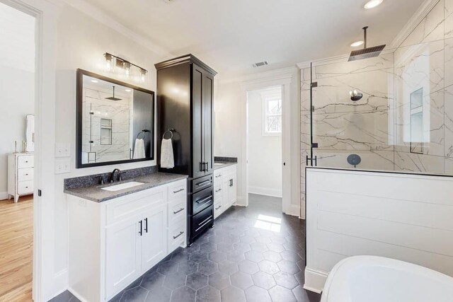 bathroom with a marble finish shower, recessed lighting, visible vents, ornamental molding, and vanity