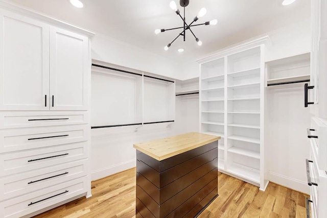 walk in closet featuring a chandelier and light wood-style floors