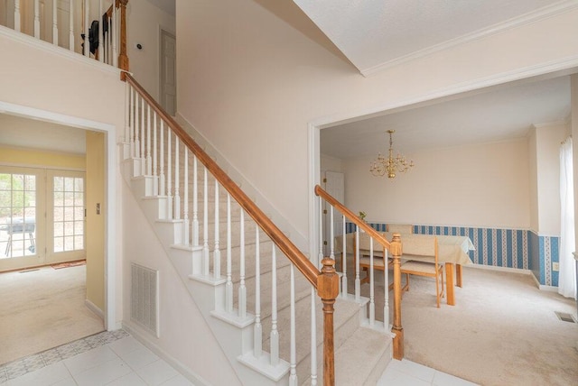 stairway featuring a high ceiling, crown molding, carpet flooring, and a notable chandelier