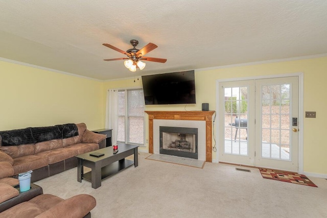 living room featuring crown molding, light carpet, ceiling fan, and a textured ceiling