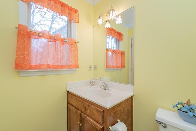 bathroom featuring vanity, crown molding, and toilet