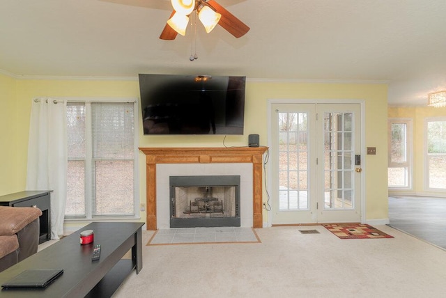 living room with carpet flooring, ornamental molding, a fireplace, and plenty of natural light