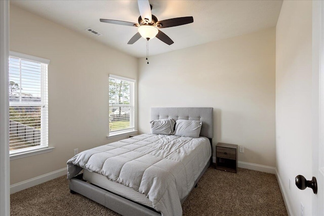 carpeted bedroom featuring ceiling fan, visible vents, and baseboards