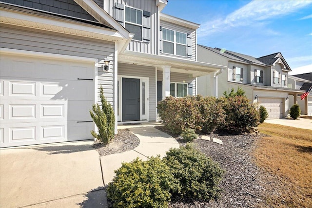 view of exterior entry featuring board and batten siding and an attached garage