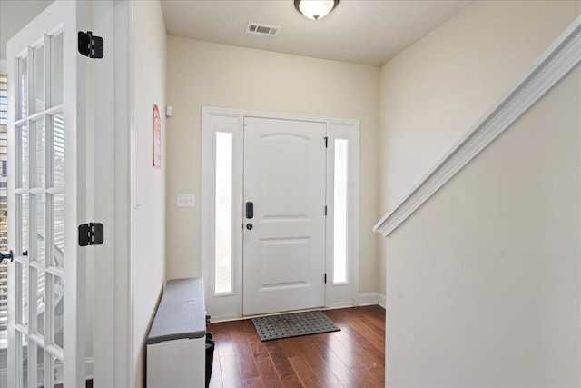 foyer featuring baseboards, visible vents, and dark wood-style flooring