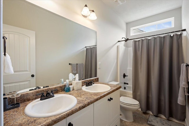 full bath with double vanity, shower / tub combo, a sink, and toilet