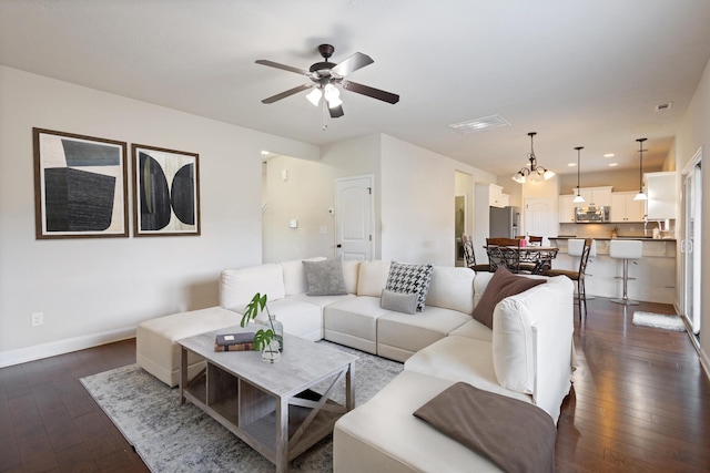 living room featuring dark wood-style floors, ceiling fan, and baseboards