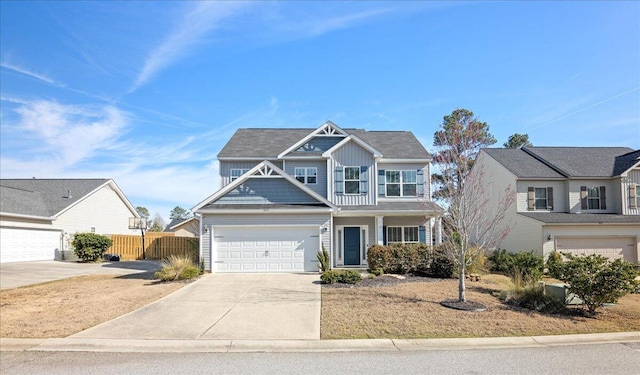 view of front of house with a garage, driveway, board and batten siding, and fence