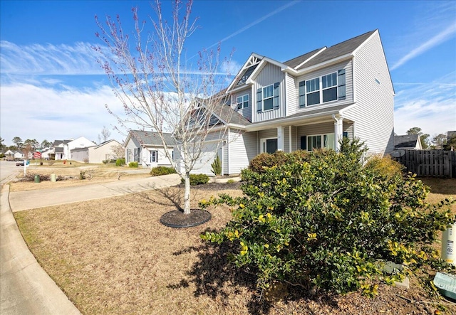 view of front of house with driveway, a garage, fence, and board and batten siding