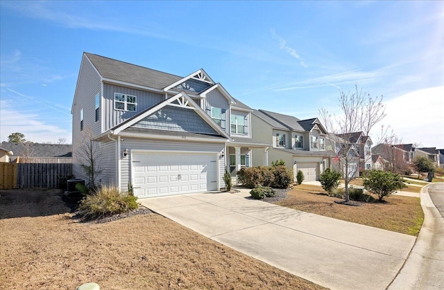 view of front of property with a garage, concrete driveway, a residential view, fence, and board and batten siding