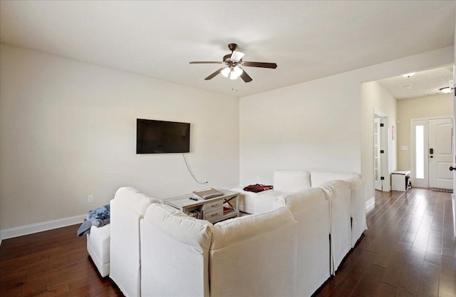 living room with a ceiling fan, dark wood-style flooring, and baseboards