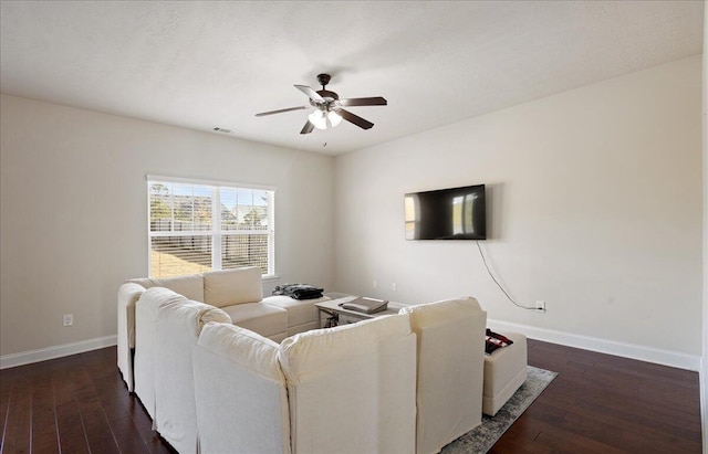 living area with dark wood-type flooring, visible vents, baseboards, and a ceiling fan