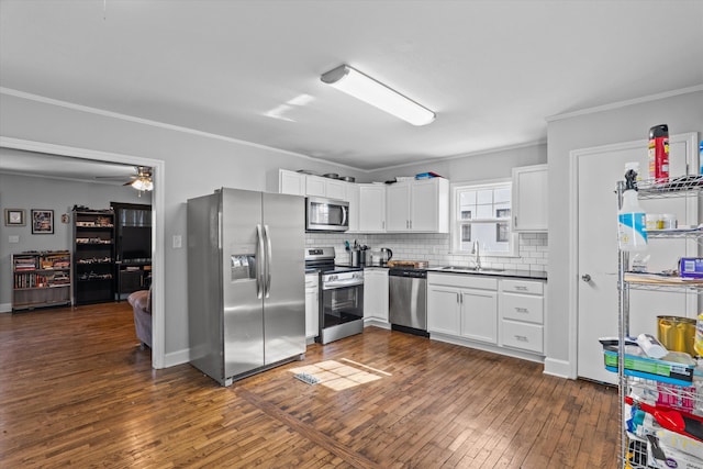 102 Oak St, Washington, GA 30673 - kitchen featuring a sink, dark countertops, dark wood finished floors, appliances with stainless steel finishes, and crown molding