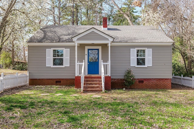 bungalow with crawl space, a shingled roof, a front lawn, and fence