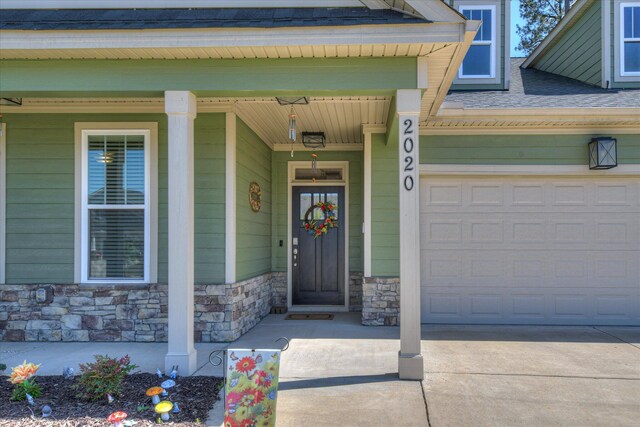 2020 Sinclair Dr, Grovetown, GA 30813 - view of exterior entry featuring stone siding, driveway, a garage, and covered porch