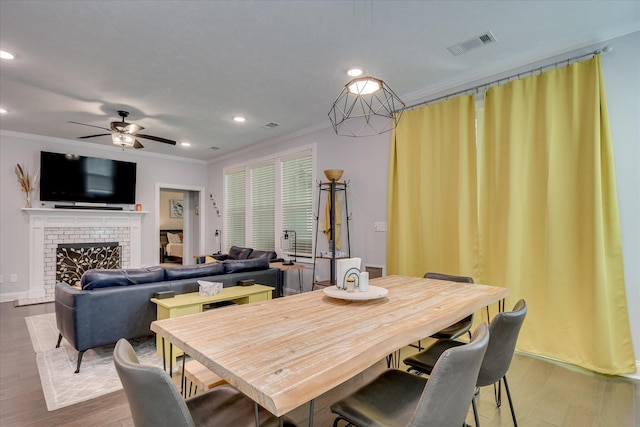 2020 Sinclair Dr, Grovetown, GA 30813 - dining area with crown molding, a ceiling fan, wood finished floors, recessed lighting, and a brick fireplace