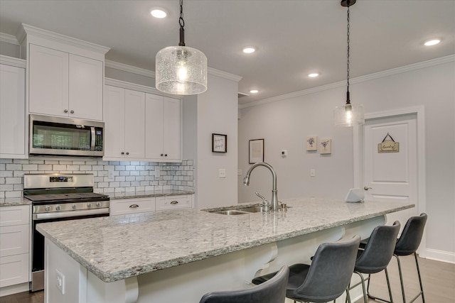 2020 Sinclair Dr, Grovetown, GA 30813 - kitchen featuring stainless steel appliances, a sink, backsplash, ornamental molding, and a kitchen island with sink