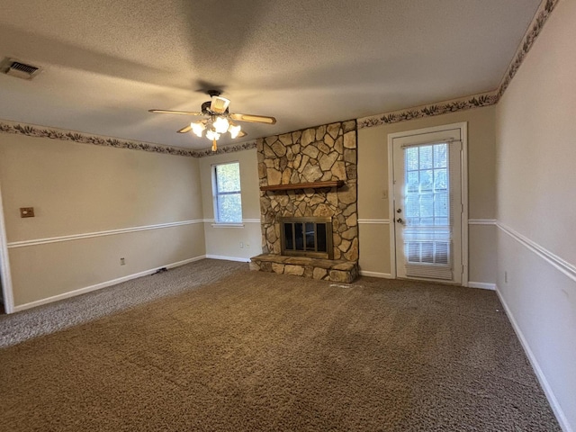 unfurnished living room featuring a fireplace, carpet, a textured ceiling, and ceiling fan