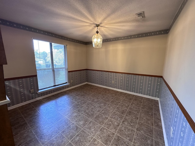 spare room featuring a textured ceiling, mail boxes, and a notable chandelier