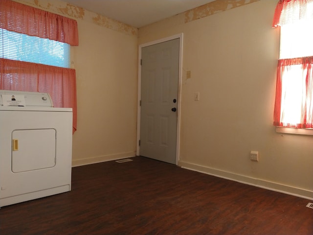 laundry area featuring washer / dryer, dark wood-type flooring, and a healthy amount of sunlight