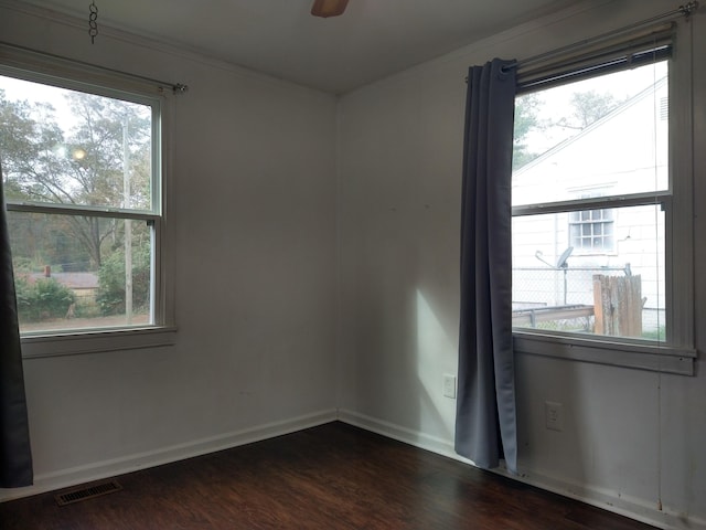 unfurnished room with crown molding, dark wood-type flooring, and ceiling fan