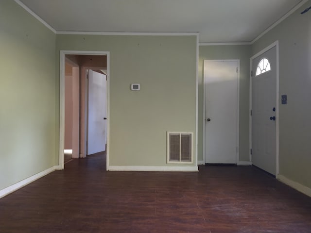 foyer with ornamental molding and dark hardwood / wood-style floors