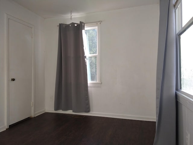 unfurnished room with dark hardwood / wood-style flooring and crown molding