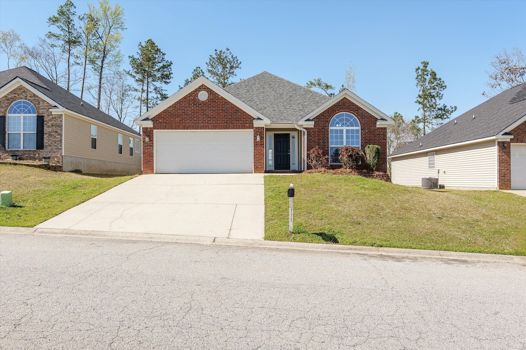 view of front of house featuring central AC unit, an attached garage, brick siding, a front lawn, and driveway