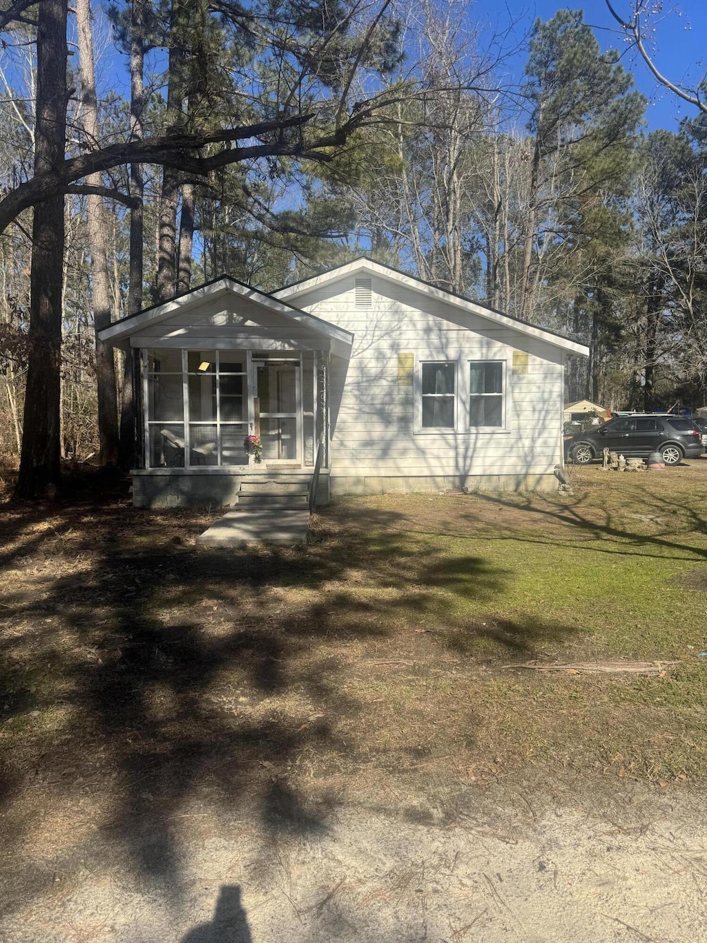 view of front of home with a front lawn and a sunroom