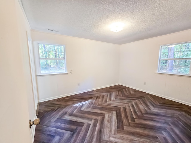 empty room with dark parquet floors and a textured ceiling