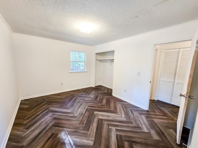 unfurnished bedroom with dark parquet flooring, a textured ceiling, and a closet