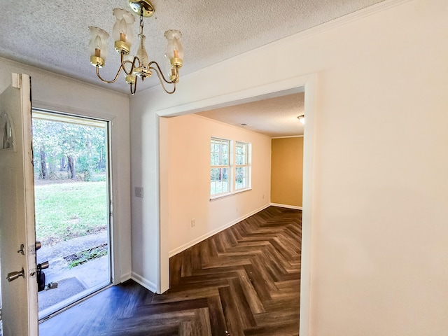 doorway with a textured ceiling, dark parquet floors, and a notable chandelier