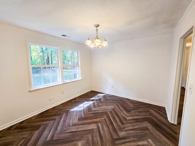 unfurnished dining area with dark parquet flooring, ornamental molding, a textured ceiling, and an inviting chandelier