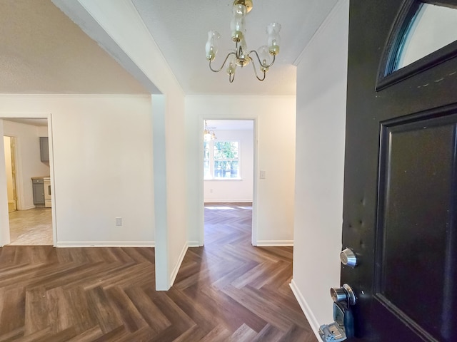 foyer with parquet flooring and an inviting chandelier