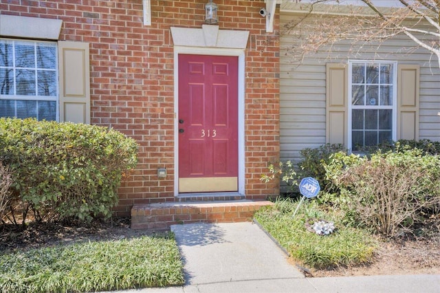 doorway to property featuring brick siding