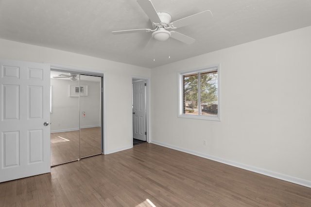 unfurnished bedroom with wood-type flooring, ceiling fan, and a closet