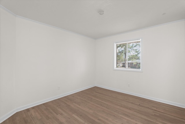 spare room with hardwood / wood-style flooring and crown molding