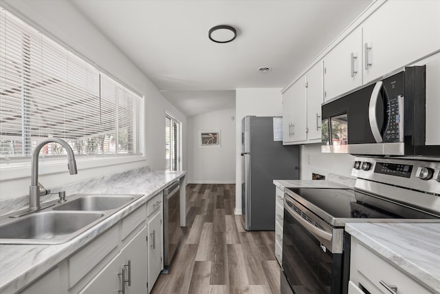 kitchen featuring sink, white cabinetry, wood-type flooring, a wealth of natural light, and stainless steel appliances