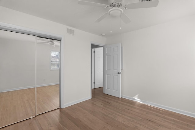 unfurnished bedroom with light hardwood / wood-style floors, a closet, and ceiling fan