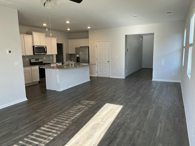 kitchen with sink, dark wood-type flooring, an island with sink, white cabinets, and appliances with stainless steel finishes