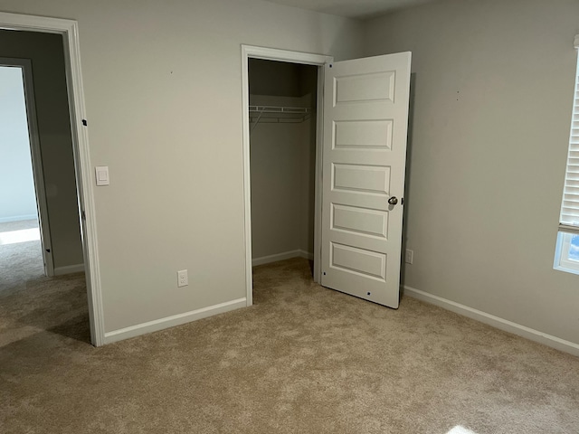 unfurnished bedroom featuring light carpet and a closet