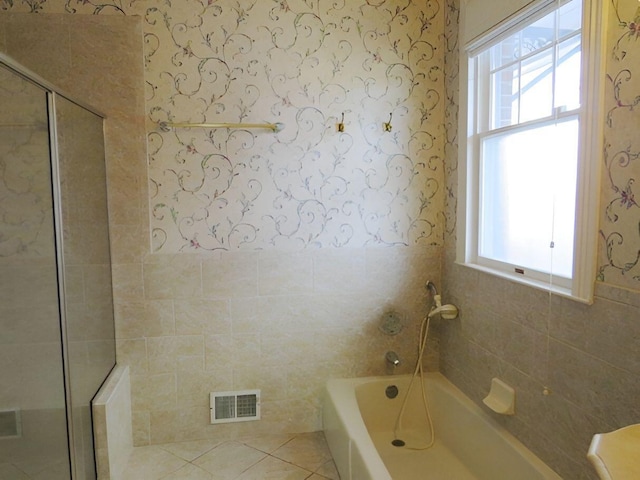 bathroom with tile walls, a wealth of natural light, and tile patterned floors