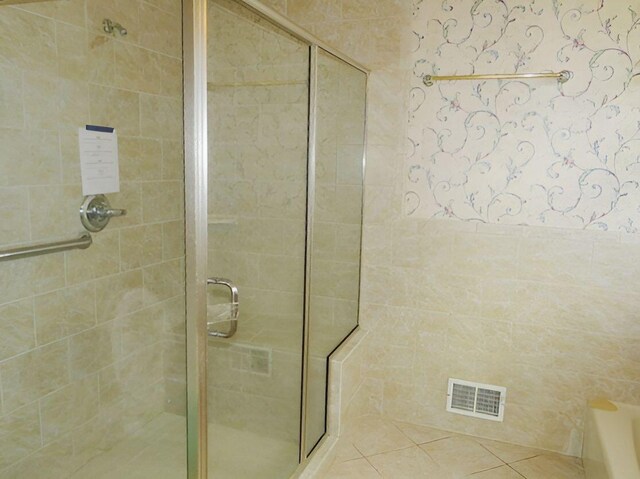 bathroom featuring tile patterned flooring and a shower with shower door