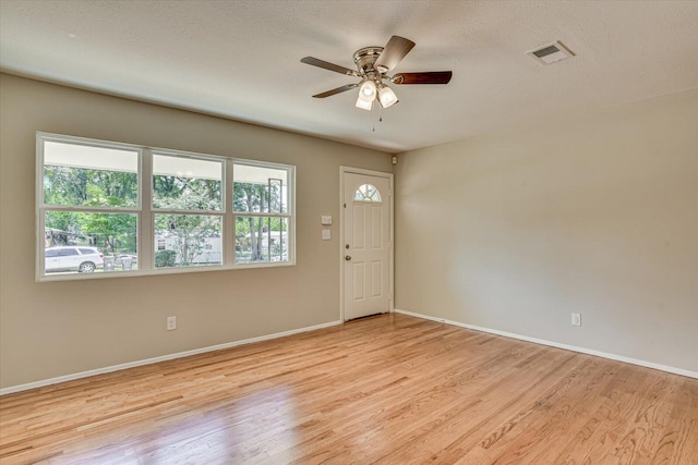 foyer with a textured ceiling, light wood-type flooring, and ceiling fan