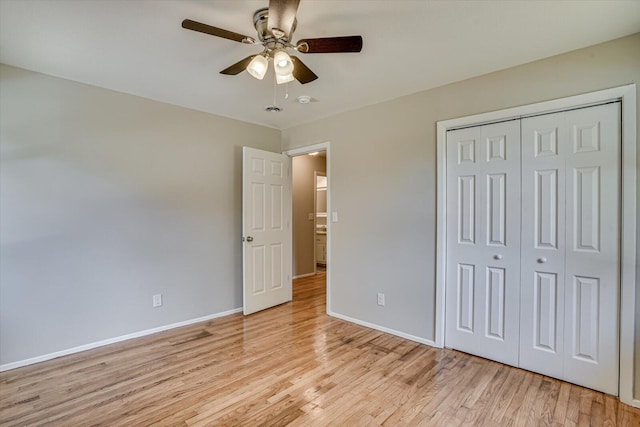 unfurnished bedroom featuring ceiling fan, a closet, and light wood-type flooring