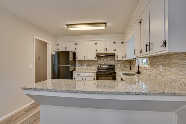 kitchen with white cabinets, sink, black / electric stove, kitchen peninsula, and stainless steel refrigerator