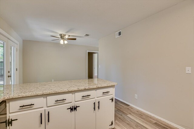 kitchen featuring white cabinetry, dishwasher, ceiling fan, light stone countertops, and light hardwood / wood-style floors